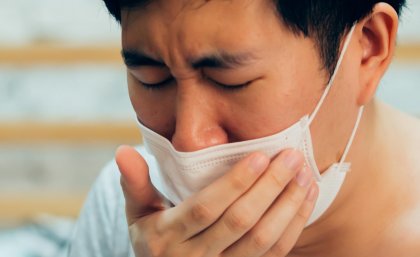 Man with mask coughing